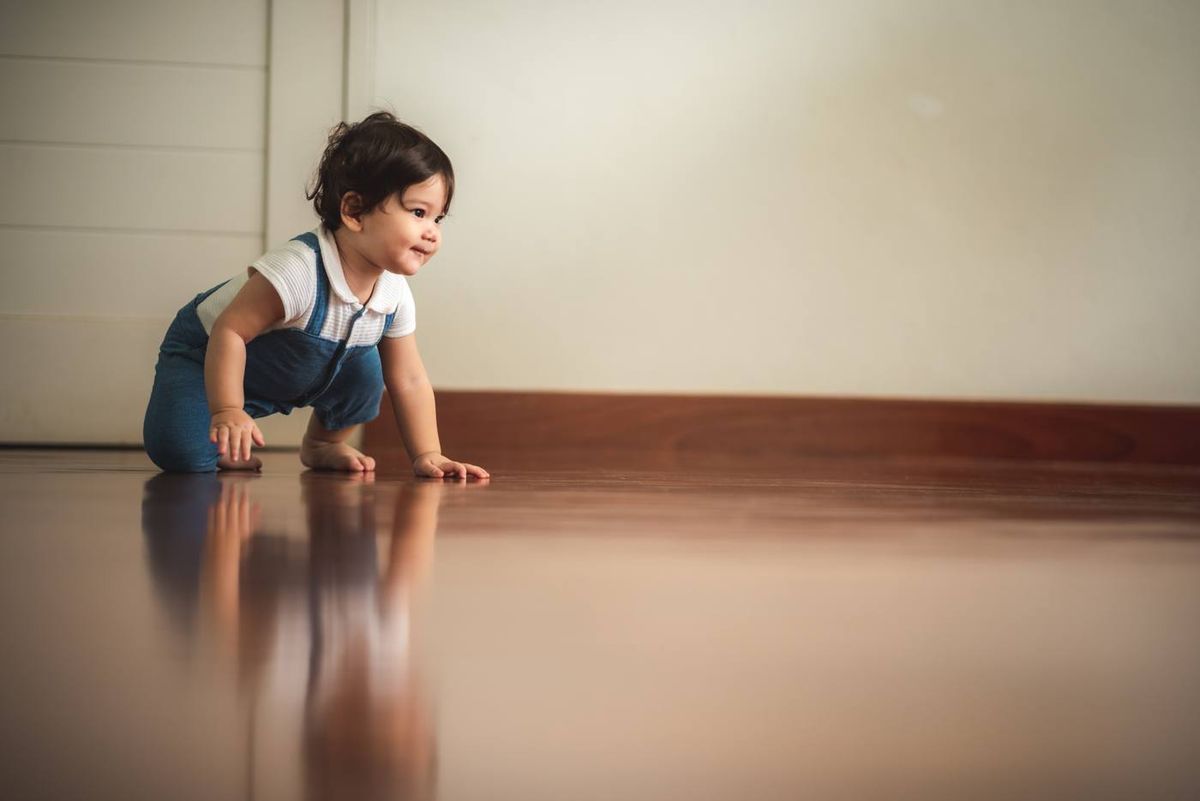 Toddler crawling across a smooth coated floor